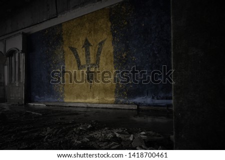 painted flag of barbados on the dirty old wall in an abandoned ruined house. concept