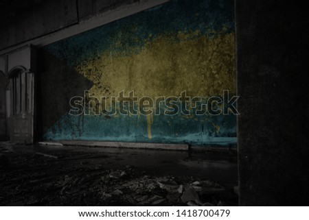 painted flag of bahamas on the dirty old wall in an abandoned ruined house. concept