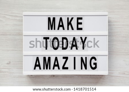 'Make today amazing' words on a modern board on a white wooden background. From above, overhead, flat lay, top view. Closeup.