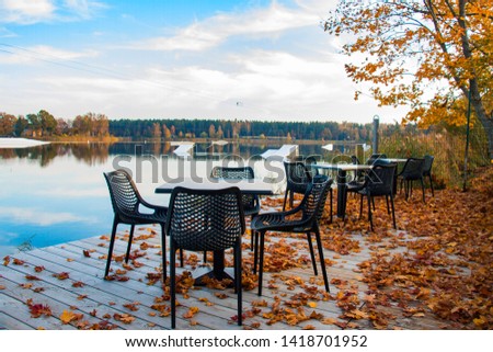 autumn landscape cafe in golden leaves by the lake