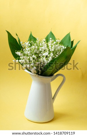 a bouquet of lilly of the valley isolated on yellow background, template for birthday or valentine's card