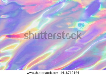 Holographic Foil Texture.  Abstract soft pastel iridescent background. Rainbow colors and sunlight spots. 