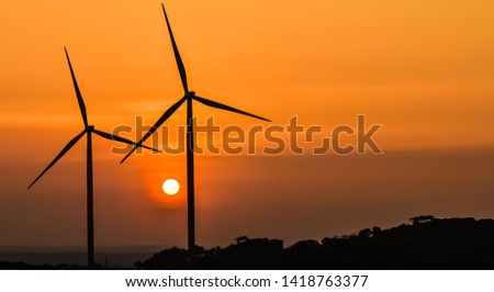 Light from the sun and wind turbines as background