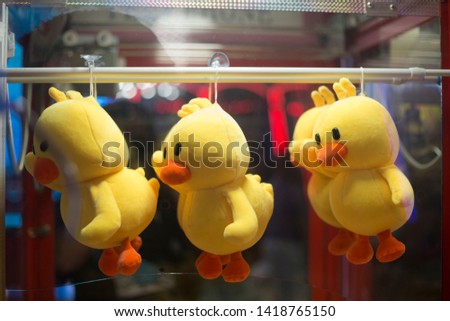 Close up of Japanese claw crane game machine soft toys and cuddly bears at the game centre .