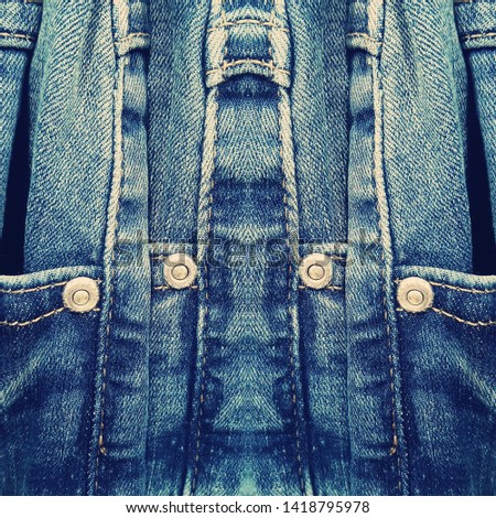 Just denim traditional blue material as jeans with metal rivets in reflected patterns