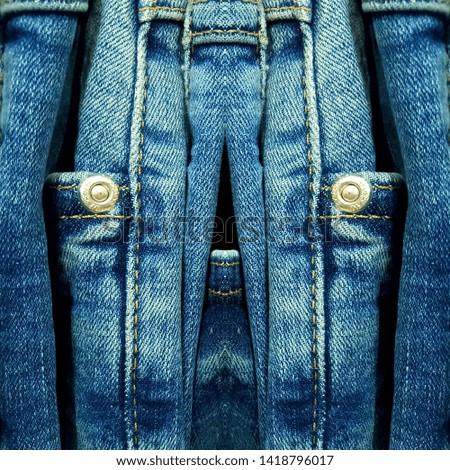 Just denim traditional blue material as jeans with metal rivets in reflected patterns