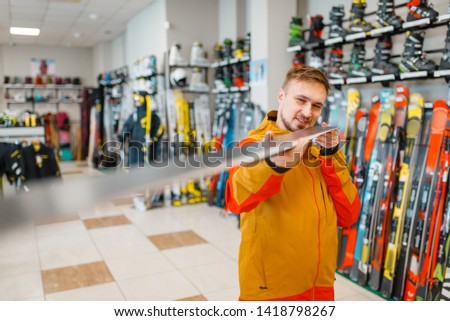 Man at the showcase checks the surface of the ski