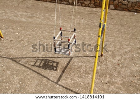 an empty swing on a playground