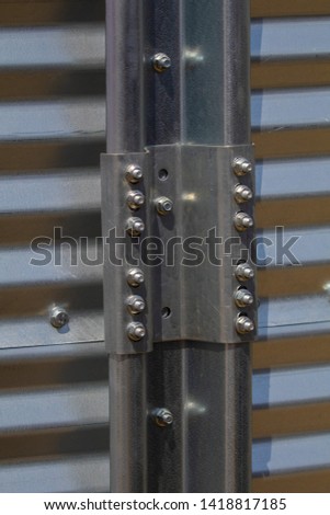 Texture of corrugated metal with fastener and rivets, background for design.