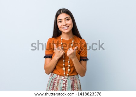 Young arab woman raising both thumbs up, smiling and confident.
