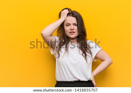 Young curvy plus size woman tired and very sleepy keeping hand on his head.