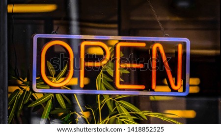 Panorama frame Close up of a neon open sign hanging on the glass wall of a commercial building