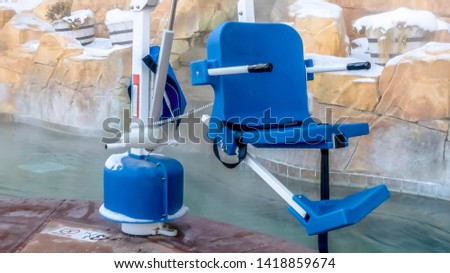 Panorama frame Blue chair with seatbelt connected to a white metal boom