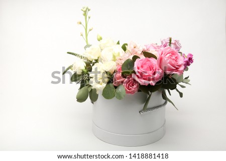 bouquet of pink and white roses flowers in a round white box on a white background with free space