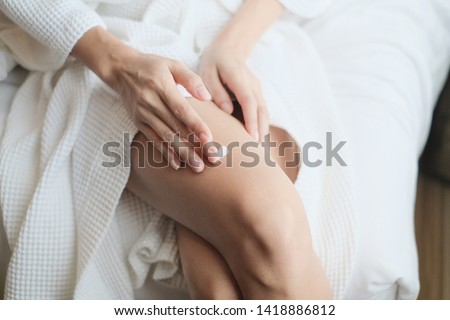 Woman applying legs cream,lotion , Hygiene skin body care concept. Royalty-Free Stock Photo #1418886812