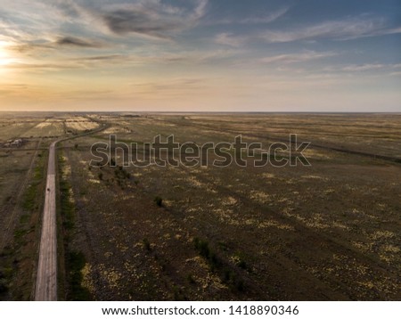 Empty asphalt road goes into the distance on sunset