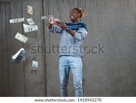 business, people and finances concept  Happy young african american businessman throwing US dollar banknotes and enjoying while making the rain of money in new startup office