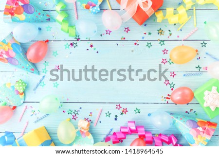 Party decoration background top view.  Festive multicolored decorations on blue wooden background toned. Flat lay style. Copy space