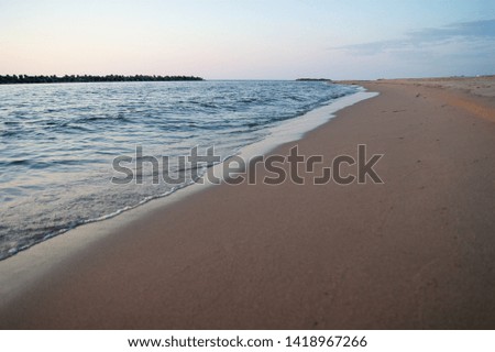 A beach lit by the sunset