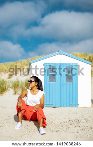 young woman at the beach of Texel Netherlands, mid age Asian woman on vacation Netherlands Texel