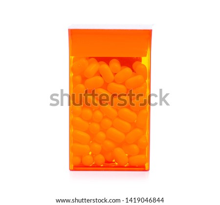 Dragee in orange container on white background isolation
