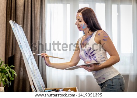 Young woman artist painting at home creative tools close-up