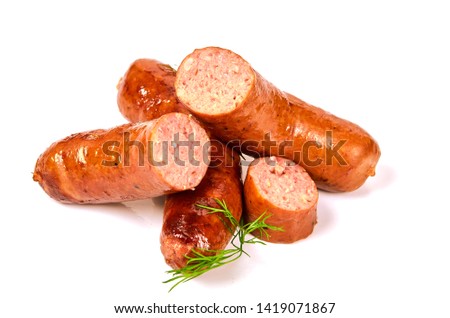 Grilled sausages with onions on a Board on a light background. Juicy sausage rings in a pile on a white background.