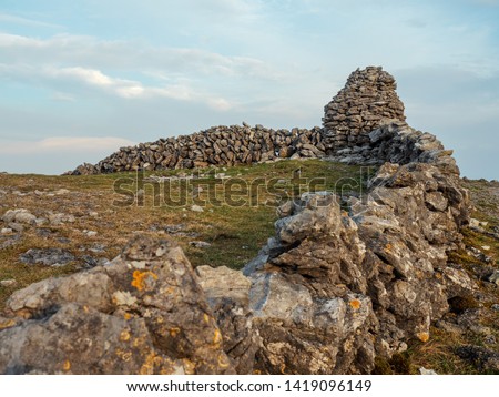 Small tower on a dry stone fence in Burren national park, Ireland, Cloudy sky, Landscape,