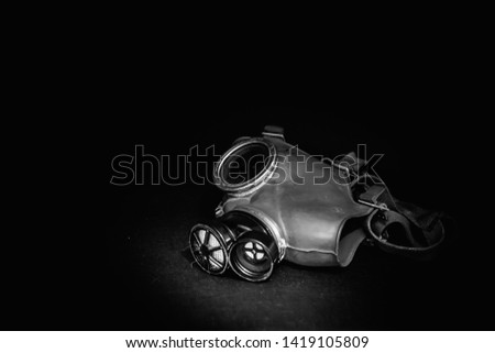 Black and white gas mask on the black background