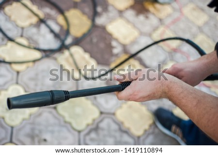 Male hands attaching hose to the pipe