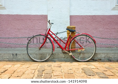 Old red bicycle on ancient street