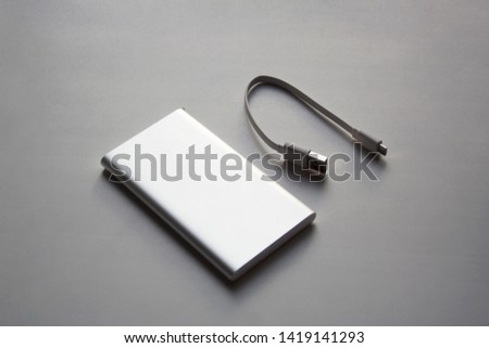 Portable aluminum power bank with USB cable isolated on white background Royalty-Free Stock Photo #1419141293
