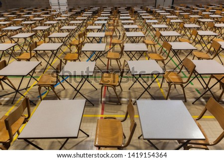 Exam tables and chairs set up in a UK school.