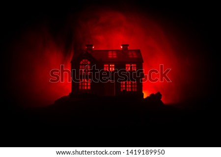 Old house with a Ghost in the forest at night or Abandoned Haunted Horror House in fog. Old mystic building in dead tree forest. Trees at night with moon. Surreal lights. Horror Halloween concept Royalty-Free Stock Photo #1419189950