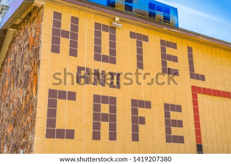 Huge Hotel And Cafe sign on the exterior wall of a building with outdoor lights