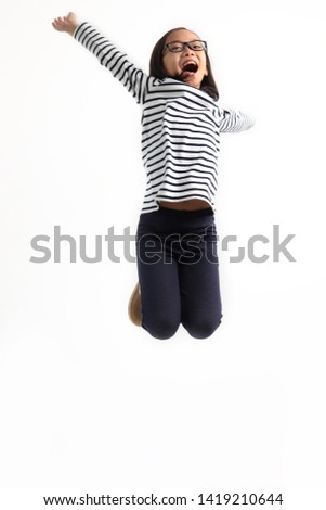 View of cheerful boy in casual clothing in moment of jump on white background