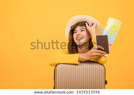 
Asian women have luggage, handles, sunglasses And holding a passport with a yellow background map in the photo studio