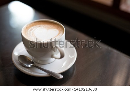 Hot coffee on a wooden table in a coffee shop
