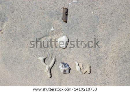 I love you written in corals, shells and sticks on the sand as a message of love for your soul mate. Romantic concept. Post card.