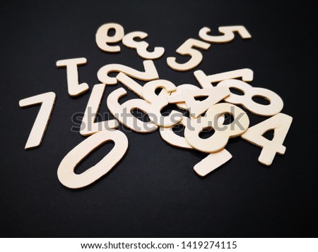 Image of wooden numbers with black colour background.