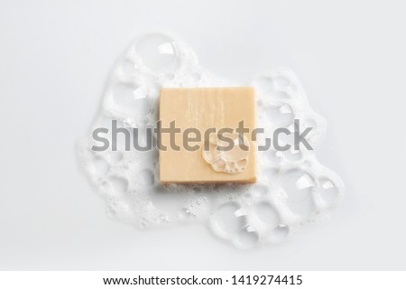 Soap bar and foam on white background, top view. Mockup for design Royalty-Free Stock Photo #1419274415