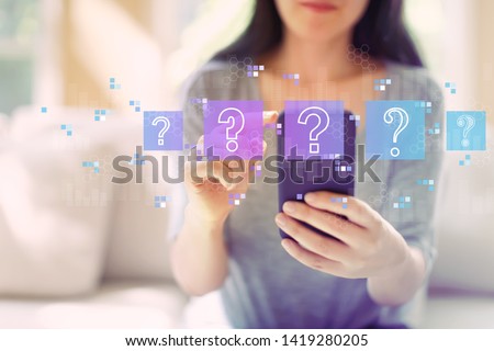 Question marks with woman using her smartphone in a living room Royalty-Free Stock Photo #1419280205