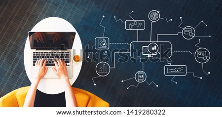 Stock trading theme with person using a laptop on a white table