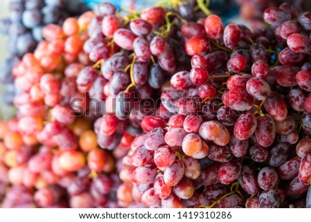 Background Close-up of purple and red grapes stacked together, commonly seen in the Thai market during the summer season