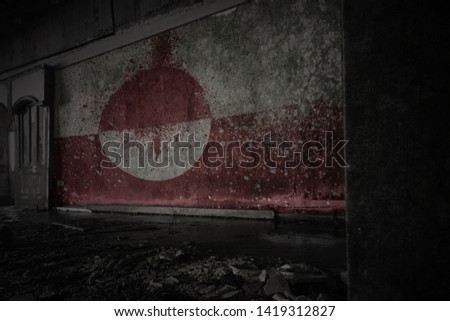 painted flag of greenland on the dirty old wall in an abandoned ruined house. concept