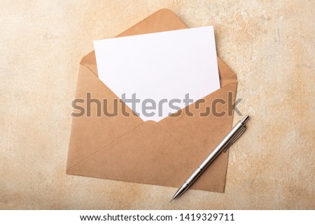 Blank paper in Kraft envelope on a light background. Clean postcard for your signatures. Top view