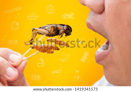 Food Insects: Man eating Bamboo Worms and Crickets insect deep-fried for eat as food snack and symbol icons media nutrition, it is good source of protein edible for future food. Entomophagy concept. Royalty-Free Stock Photo #1419341573