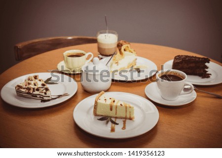 Various cakes and coffee on a table in a cafe, top view