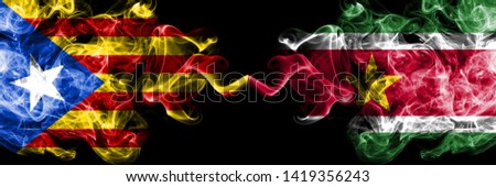 Catalonia vs Suriname, Surinamese smoke flags placed side by side. Thick colored silky smoke flags of Catalonia and Suriname, Surinamese
