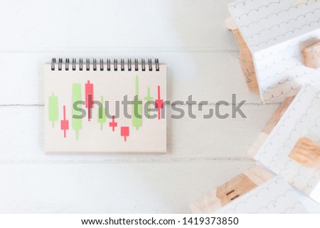 Property investment, Candlestick chart make from color paper Green and red on paper notebook, Miniature house model, financial concept, financial concept